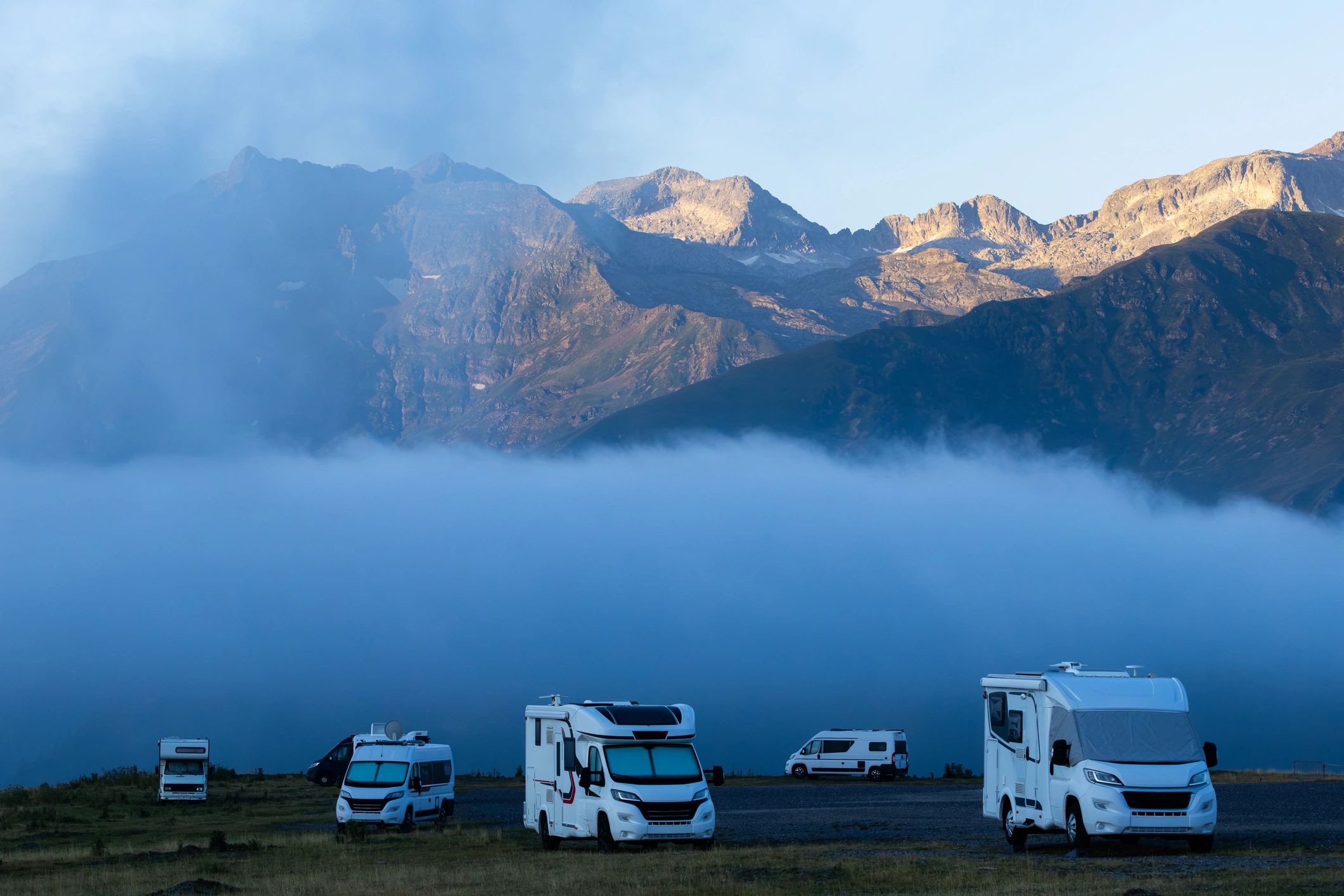 Motorhomes parked on a mountain plateau at sunrise